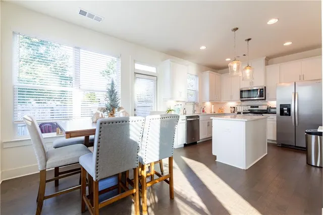 a view of kitchen with refrigerator and wooden floor