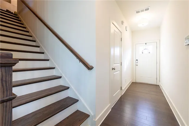 a view of a hallway with wooden floor and entryway