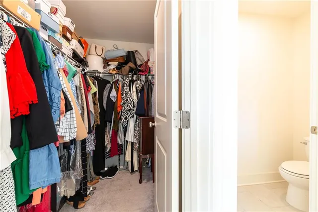 a view of walk in closet with clothes