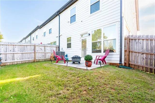 a view of a backyard with wooden fence and a bench