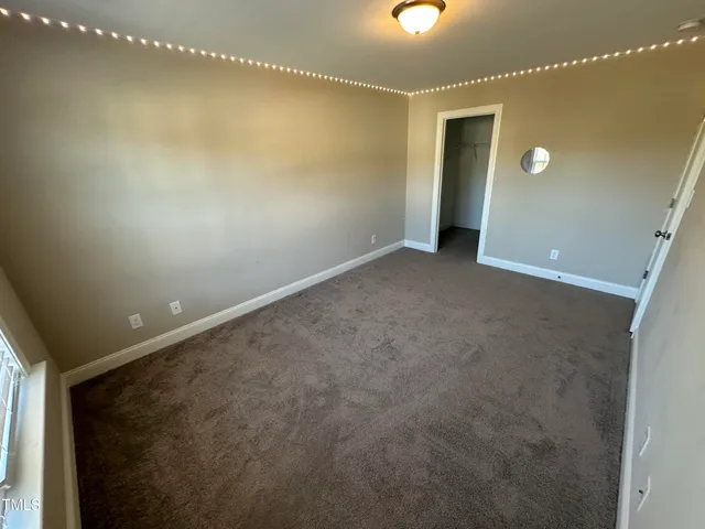 a view of a room with a ceiling fan and window