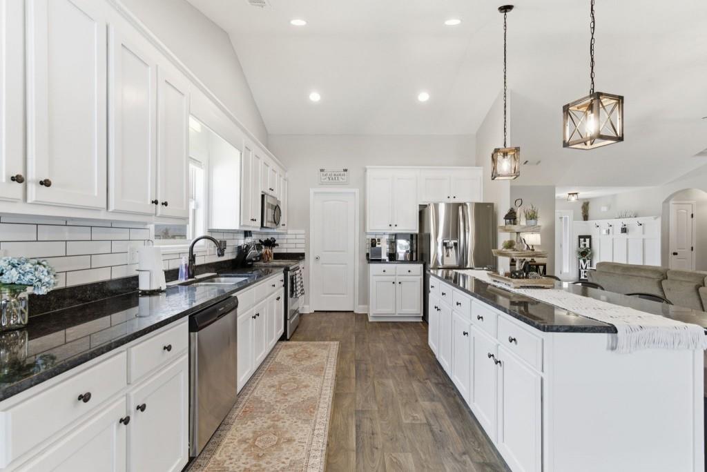844 River Mist Circle Jefferson, GA 30549 - Photo 12 of 35 a large kitchen with stainless steel appliances kitchen island granite countertop a sink and dishwasher a stove with wooden floor