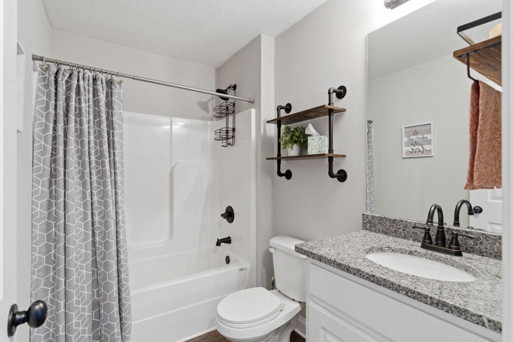 844 River Mist Circle Jefferson, GA 30549 - Photo 23 of 35 a bathroom with a granite countertop bathtub shower sink vanity mirror and toilet