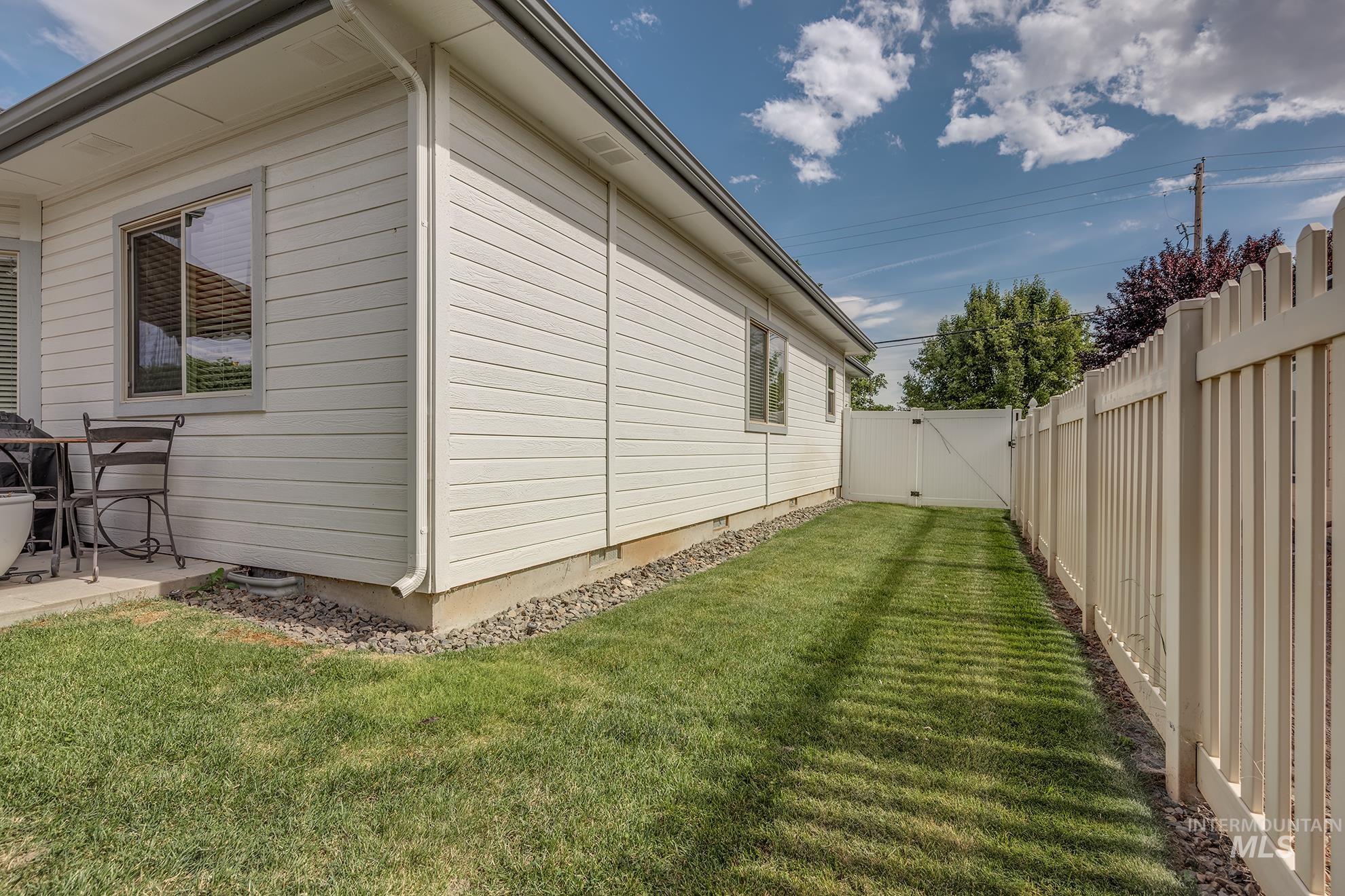 420 West Indianhead Road Weiser, ID 83672 - Photo 35 of 40 Side yard featuring a white picket fence, a privacy gate, and a grass pathway