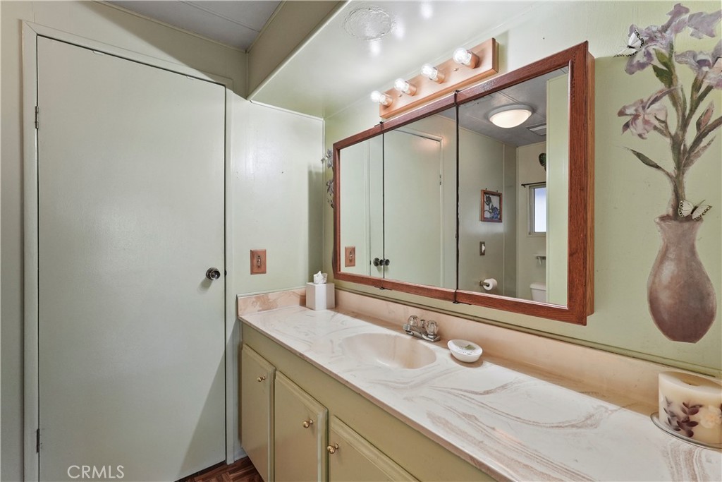 650 South Rancho Santa Fe Road, Unit 106 San Marcos, CA 92078 - Photo 25 of 55 a bathroom with a granite countertop sink and a mirror