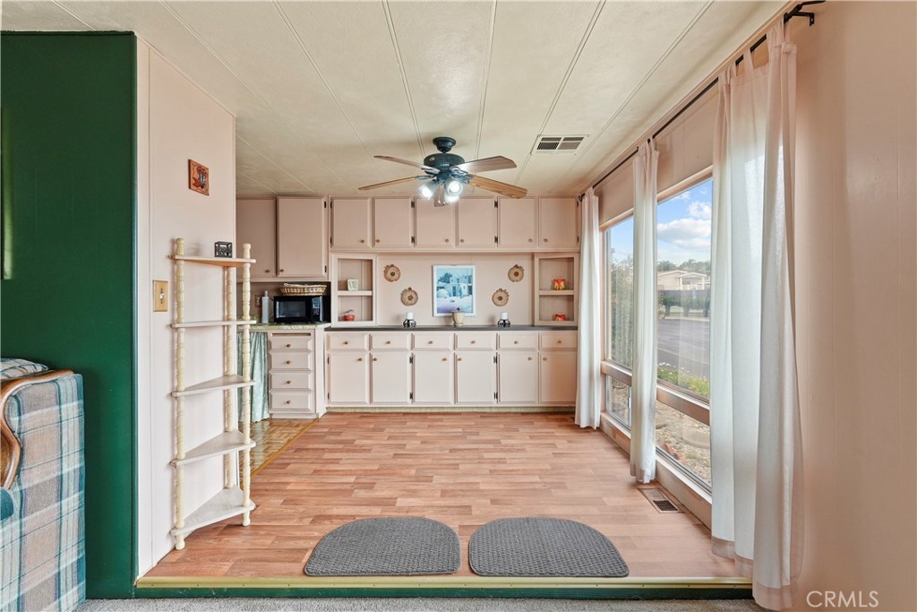 650 South Rancho Santa Fe Road, Unit 106 San Marcos, CA 92078 - Photo 37 of 55 a kitchen with stainless steel appliances kitchen island granite countertop a refrigerator and microwave