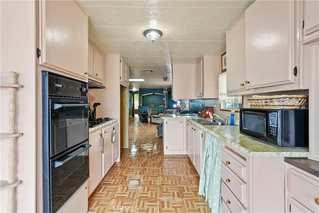 650 South Rancho Santa Fe Road, Unit 106 San Marcos, CA 92078 - Photo 39 of 55 a kitchen with stainless steel appliances granite countertop a refrigerator a oven and white cabinets