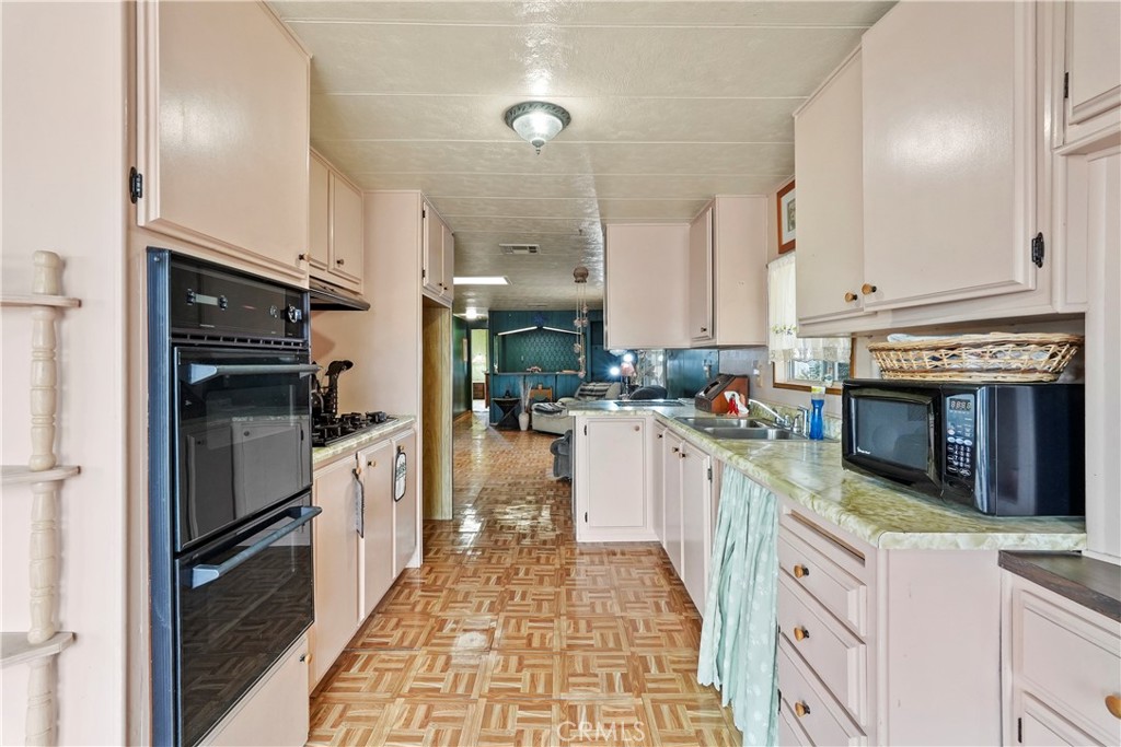 650 South Rancho Santa Fe Road, Unit 106 San Marcos, CA 92078 - Photo 41 of 55 a kitchen with stainless steel appliances granite countertop a refrigerator a oven and white cabinets