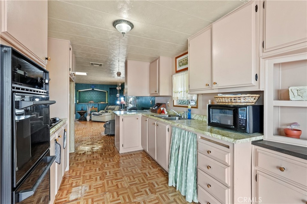 650 South Rancho Santa Fe Road, Unit 106 San Marcos, CA 92078 - Photo 42 of 55 a kitchen with stainless steel appliances kitchen island granite countertop a stove a sink and a refrigerator