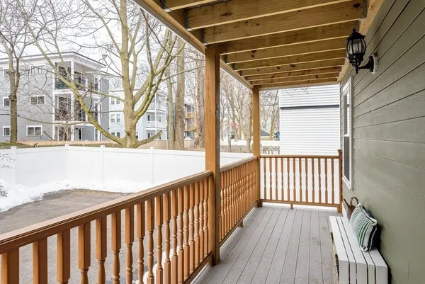 a view of a porch with wooden floor and floor to ceiling window