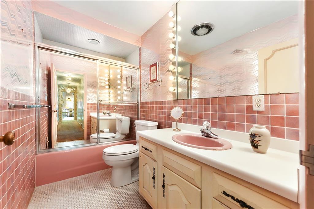 154 Gilda Avenue Pittsburgh, PA 15217 - Photo 17 of 25 a bathroom with a sink a toilet and a large mirror next to a window