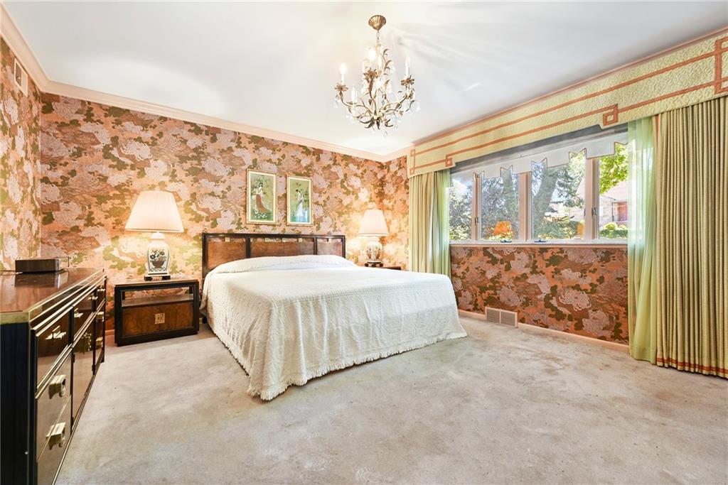 154 Gilda Avenue Pittsburgh, PA 15217 - Photo 18 of 25 a spacious bedroom with a large bed and a chandelier