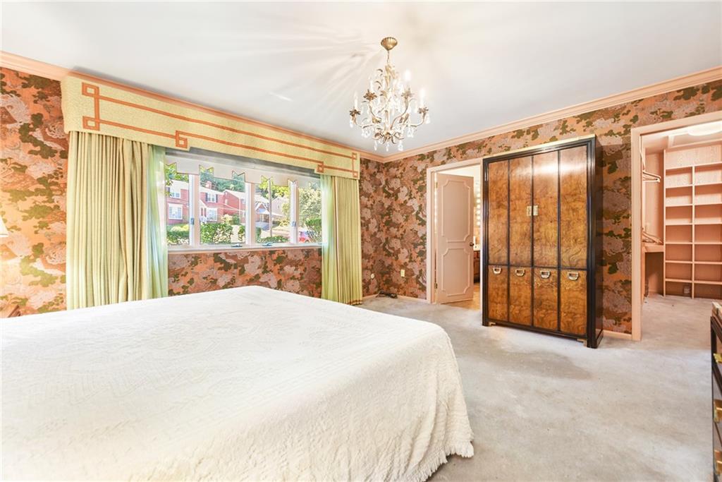 154 Gilda Avenue Pittsburgh, PA 15217 - Photo 19 of 25 a spacious bedroom with a large bed and a chandelier