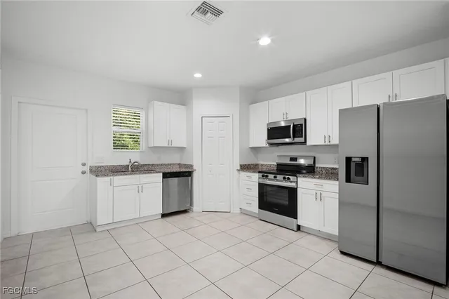 a kitchen with granite countertop appliances cabinets and a sink