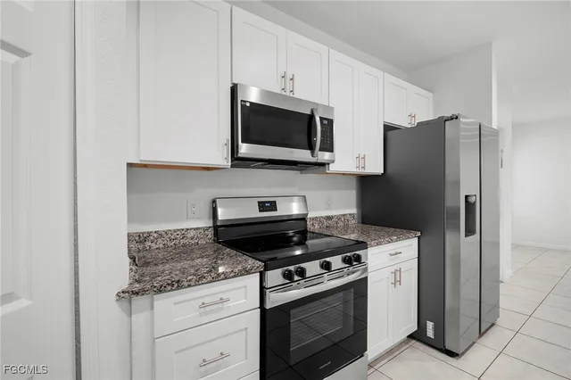 a kitchen with stainless steel appliances granite countertop a stove a refrigerator and a microwave