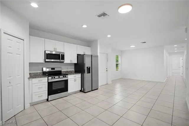 a kitchen with stainless steel appliances granite countertop a refrigerator and a stove top oven