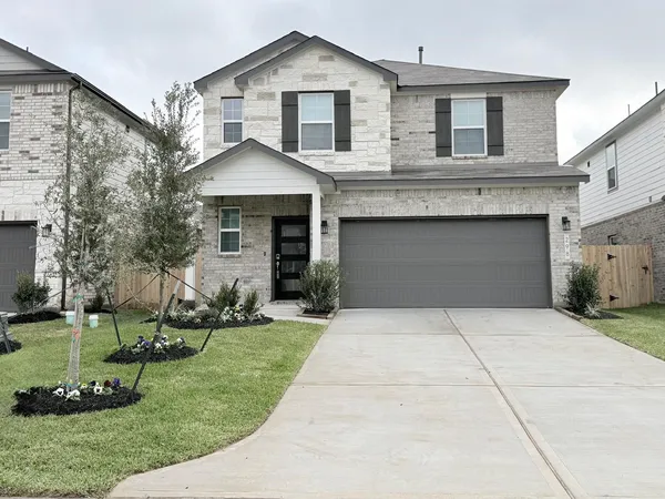 a front view of a house with a yard and a garage