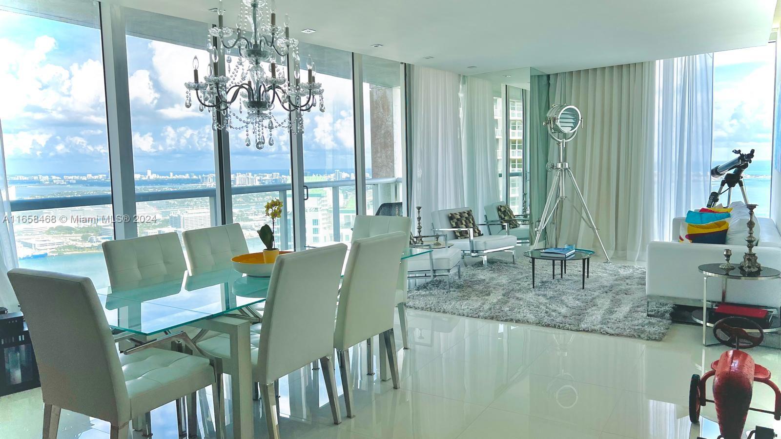 495 Brickell Avenue, Unit 4902 Miami, FL 33131 - Photo 3 of 24 a view of a dining room with furniture a chandelier and large windows