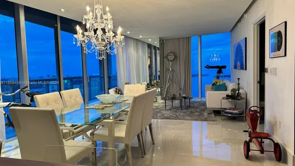 a view of a dining room with furniture and a chandelier