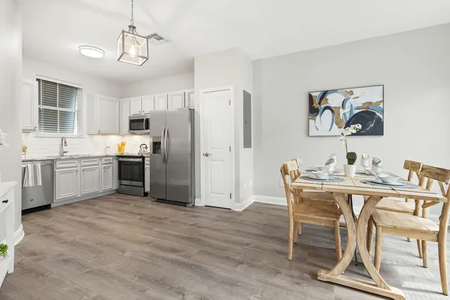a view of kitchen with stainless steel appliances granite countertop a dining table and chairs