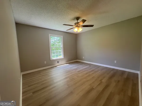 an empty room with a window and wooden floor