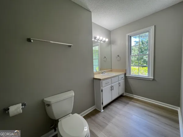 a bathroom with a granite countertop toilet a mirror and a sink