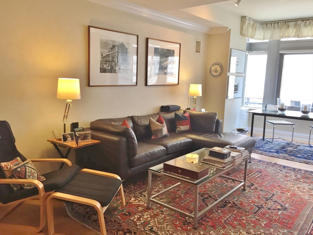 1 Huntington Avenue, Unit 405 Boston, MA 02116 - Photo 3 of 12 a living room with furniture a lamp and a dining table
