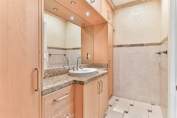 a bathroom with a granite countertop sink a mirror and vanity