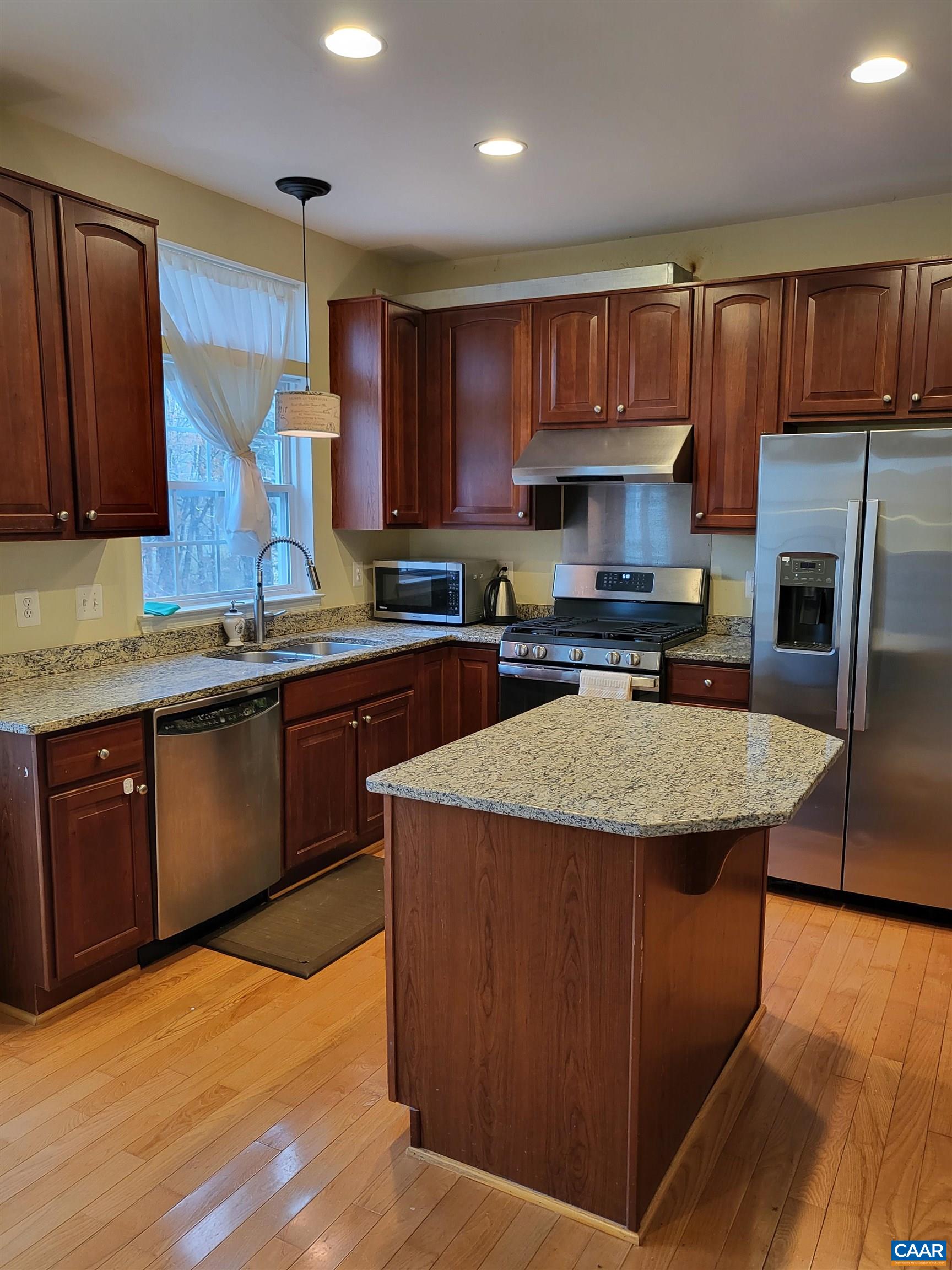 712 Rainier Road Charlottesville, VA 22903 - Photo 2 of 11 a kitchen with stainless steel appliances granite countertop wooden cabinets a sink a stove a refrigerator and cabinets