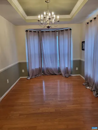a view of a room with wooden floor and chandelier