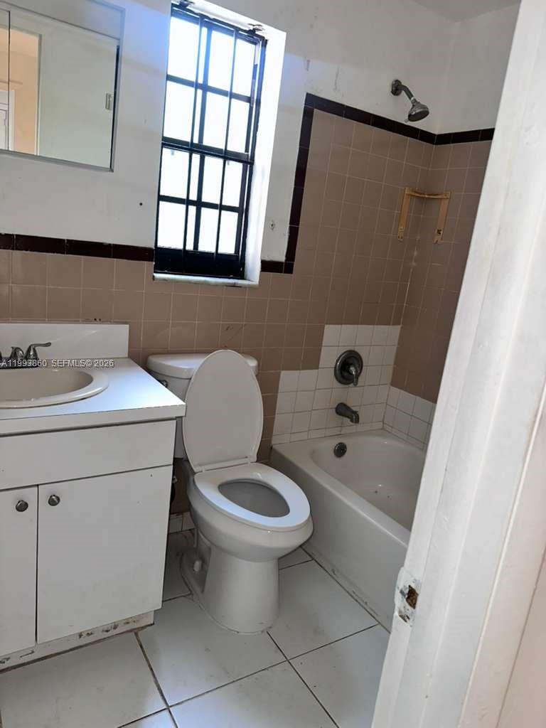 576 Northwest 147th Street, Unit 576 Miami, FL 33168 - Photo 12 of 18 a bathroom with a sink toilet and window