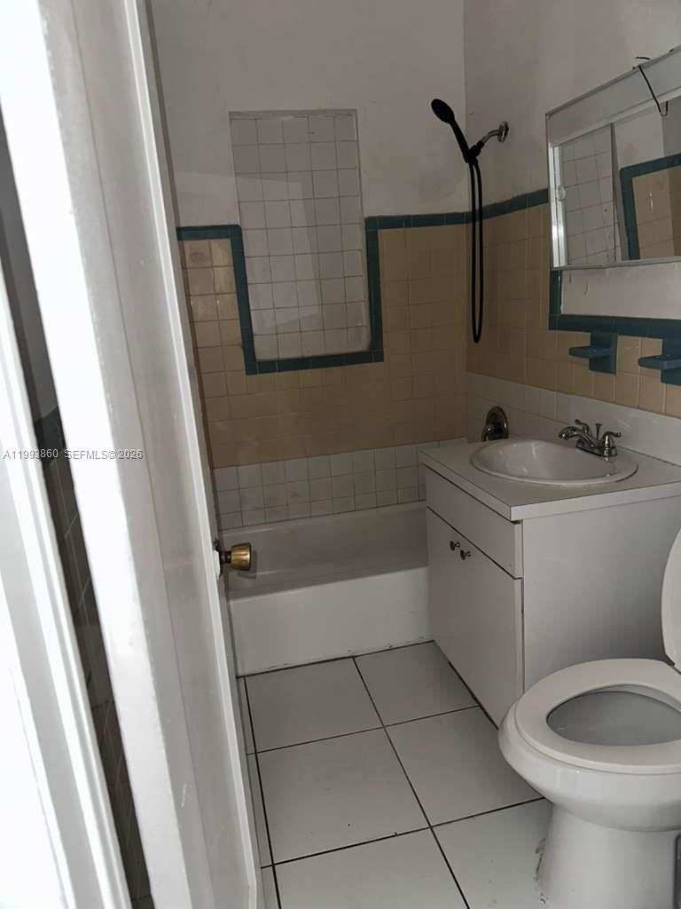 576 Northwest 147th Street, Unit 576 Miami, FL 33168 - Photo 16 of 18 a bathroom with a sink a toilet and mirror