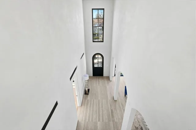 a view of staircase with wooden floor and mirror
