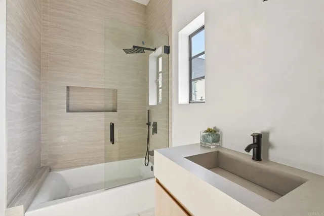 a bathroom with a tub a sink and mirror
