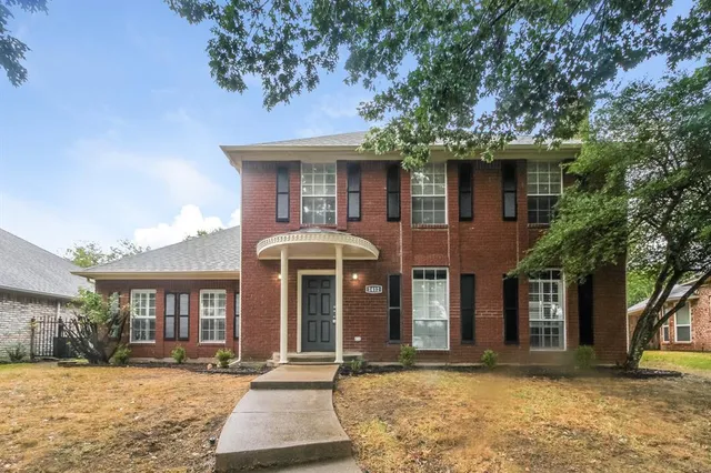 a front view of a house with yard and parking