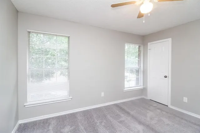 an empty room with windows and closet