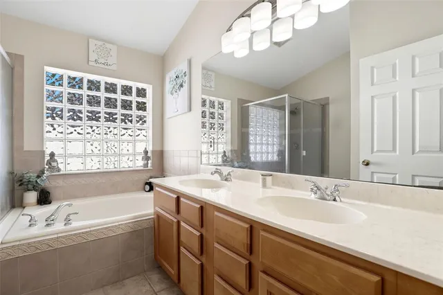 a bathroom with a tub a sink and a large mirror