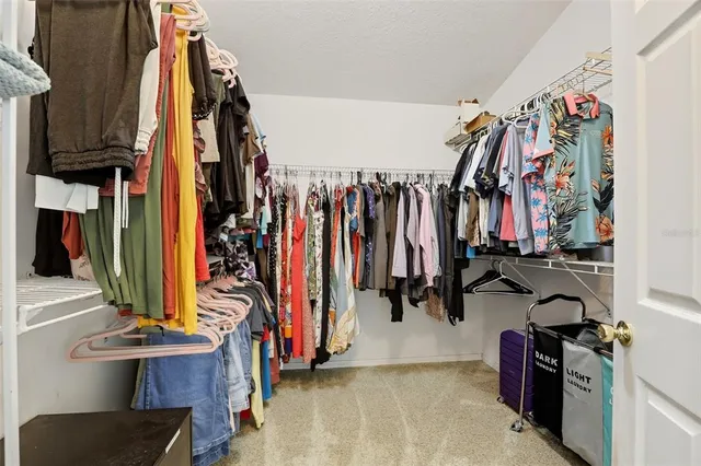 a view of walk in closet with clothes