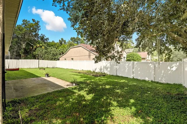 a backyard of a house with a garden and tree