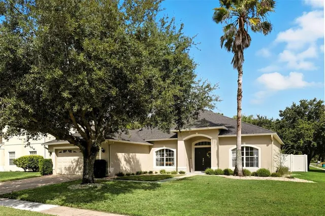 a front view of a house with a garden and trees