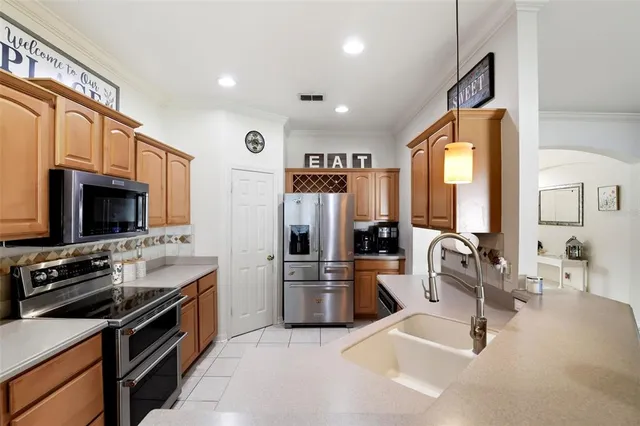 a kitchen with stainless steel appliances kitchen island granite countertop a stove top oven a sink a dining table and chairs