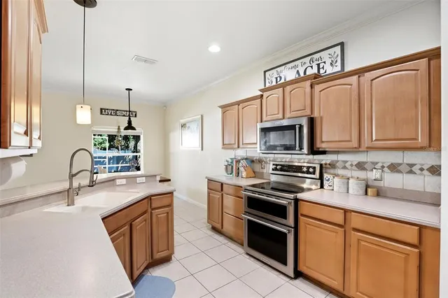 a kitchen with stainless steel appliances granite countertop a sink stove and microwave