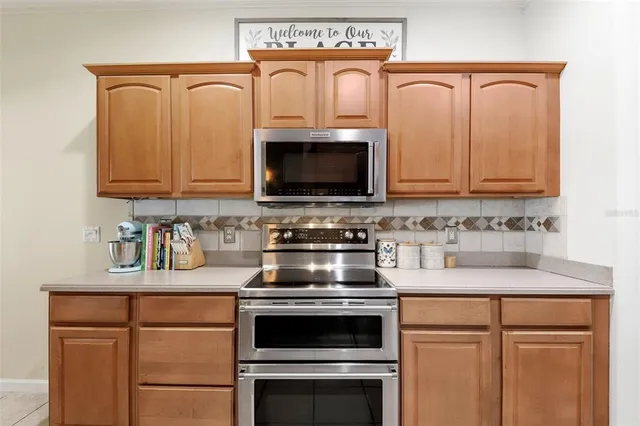 a kitchen with granite countertop white cabinets stove and microwave
