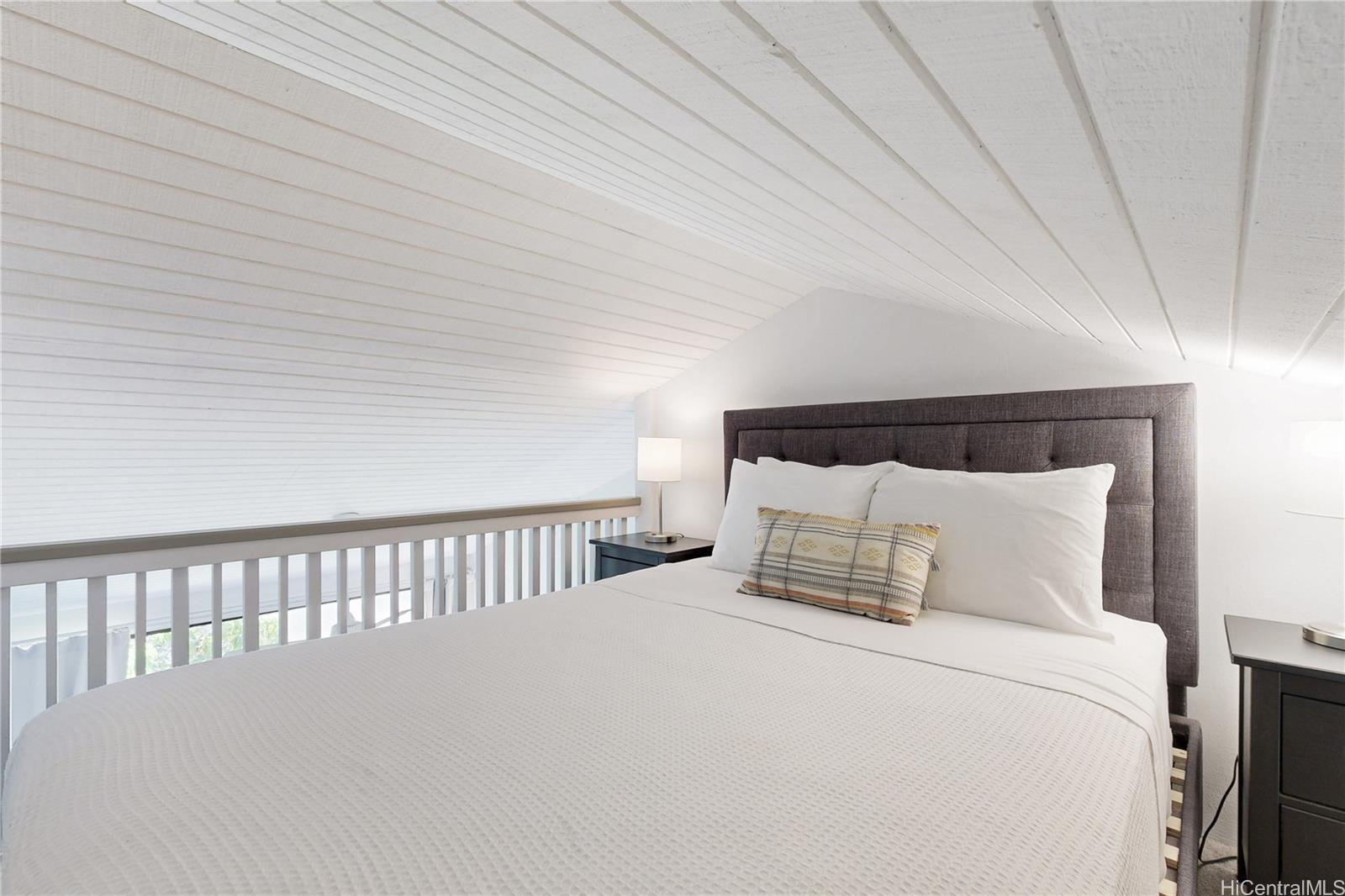 57-101 Kuilima Drive, Unit 132F Kahuku, HI 96731 - Photo 13 of 25 a large bed sitting in a bedroom next to a window