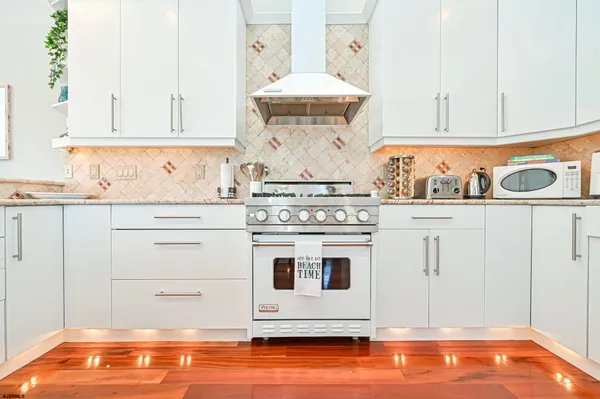 a kitchen with granite countertop white cabinets and white appliances