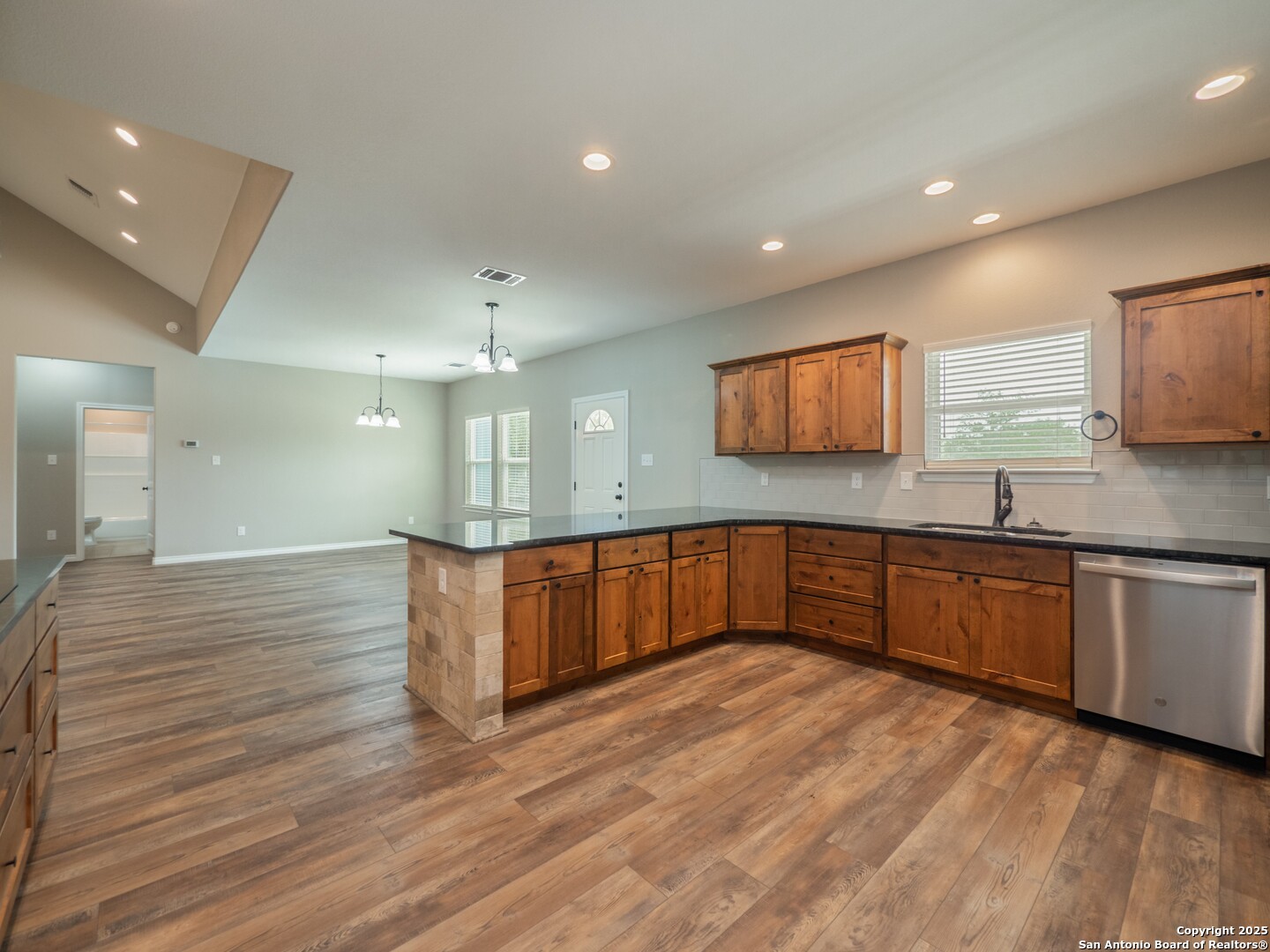 182 Inwood Poteet, TX 78065 - Photo 10 of 45 a kitchen with stainless steel appliances granite countertop a sink wooden cabinets and wooden floor