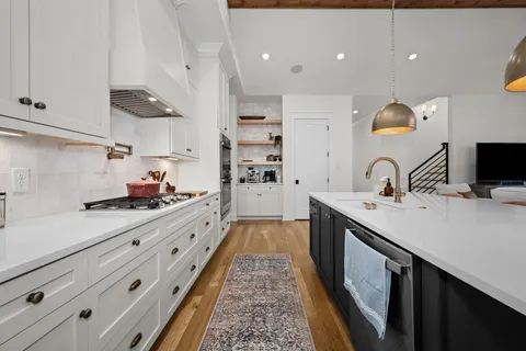 a kitchen with stainless steel appliances a sink stove and cabinets
