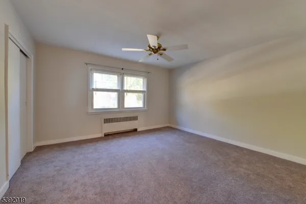 an empty room with a window and a ceiling fan