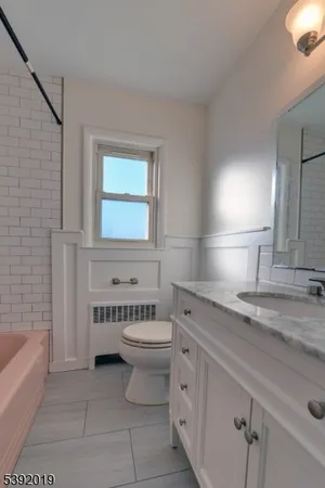 a bathroom with a granite countertop sink a toilet and bathtub