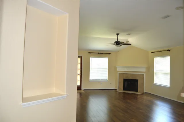 a view of a hallway with wooden floor and cabinet